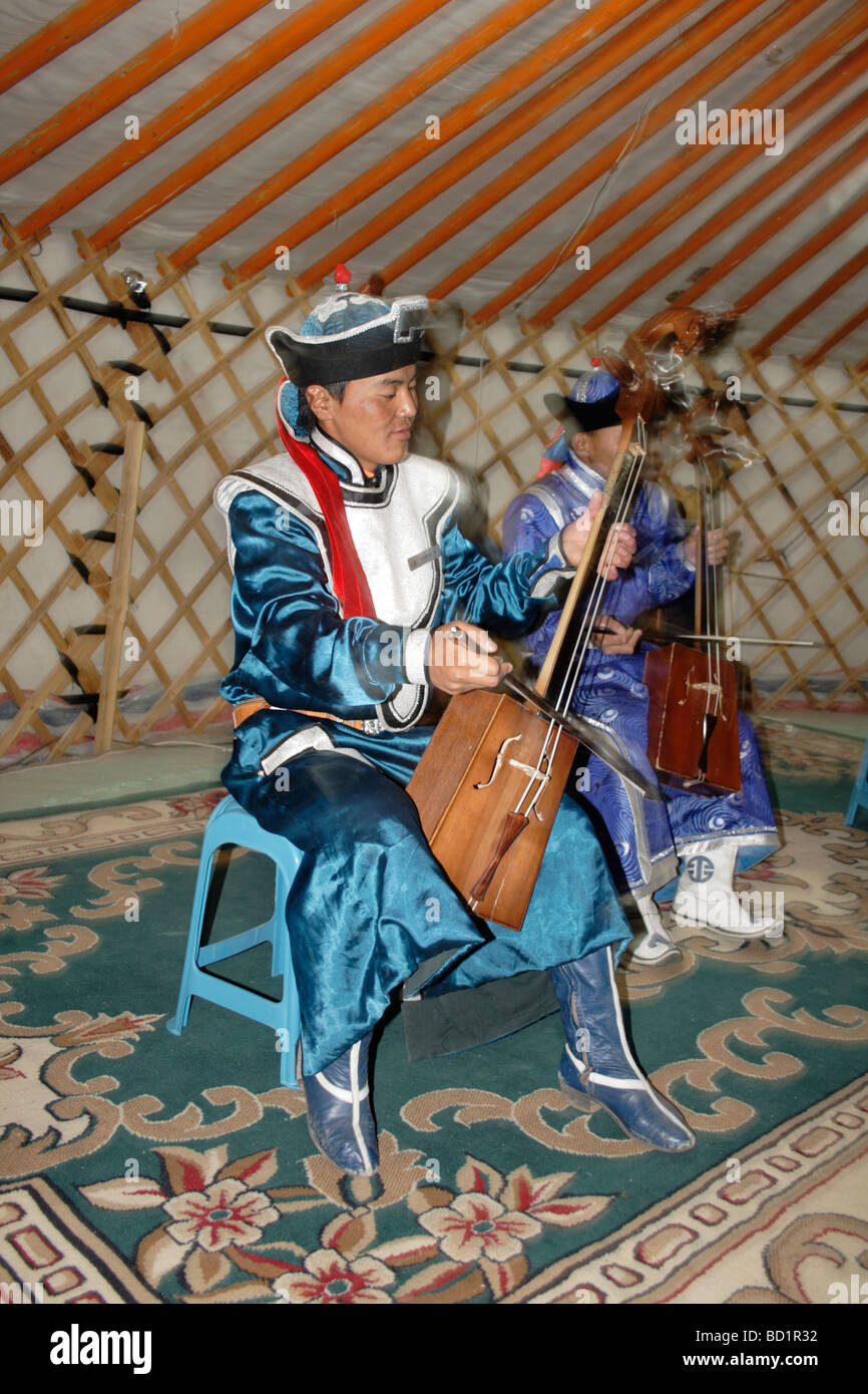 Musicista mongola riproduzione di morin khuur e indossando abiti tradizionali, Mongolia Foto Stock