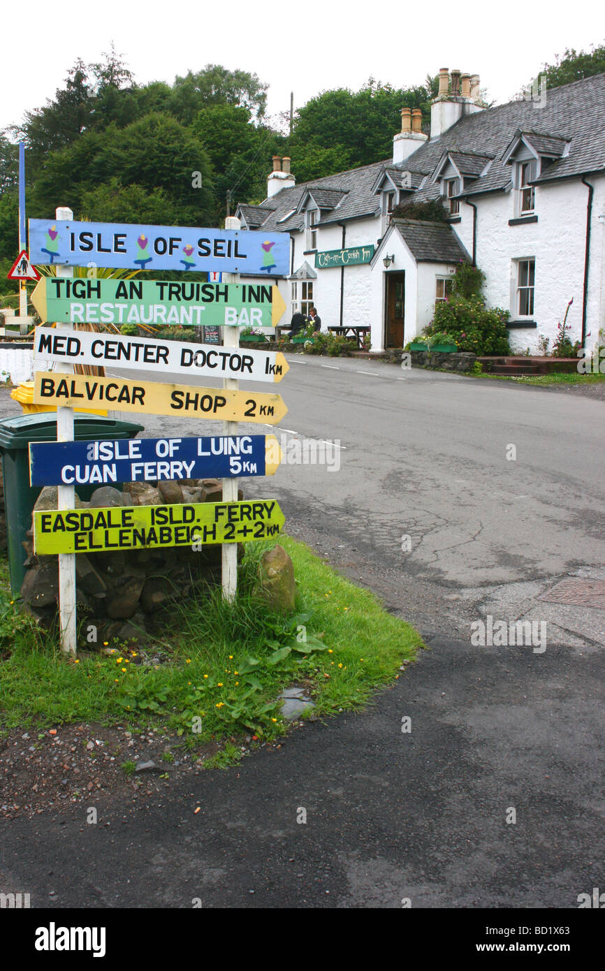 Segni di direzione presso il Tigh un Truish (la casa dei pantaloni) sull'isola di Seil, costa ovest della Scozia Foto Stock
