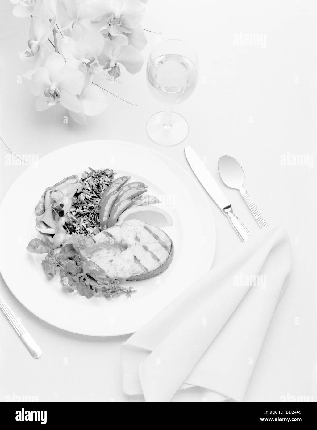 Un luogo impostazione con un salmone e fiori in bianco e nero Foto Stock