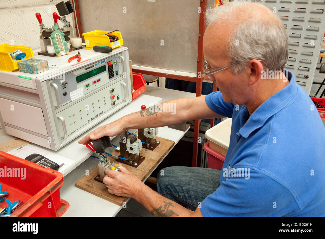 Lavoratore utilizzando apparecchiatura di prova automatizzata in una fabbrica Foto Stock