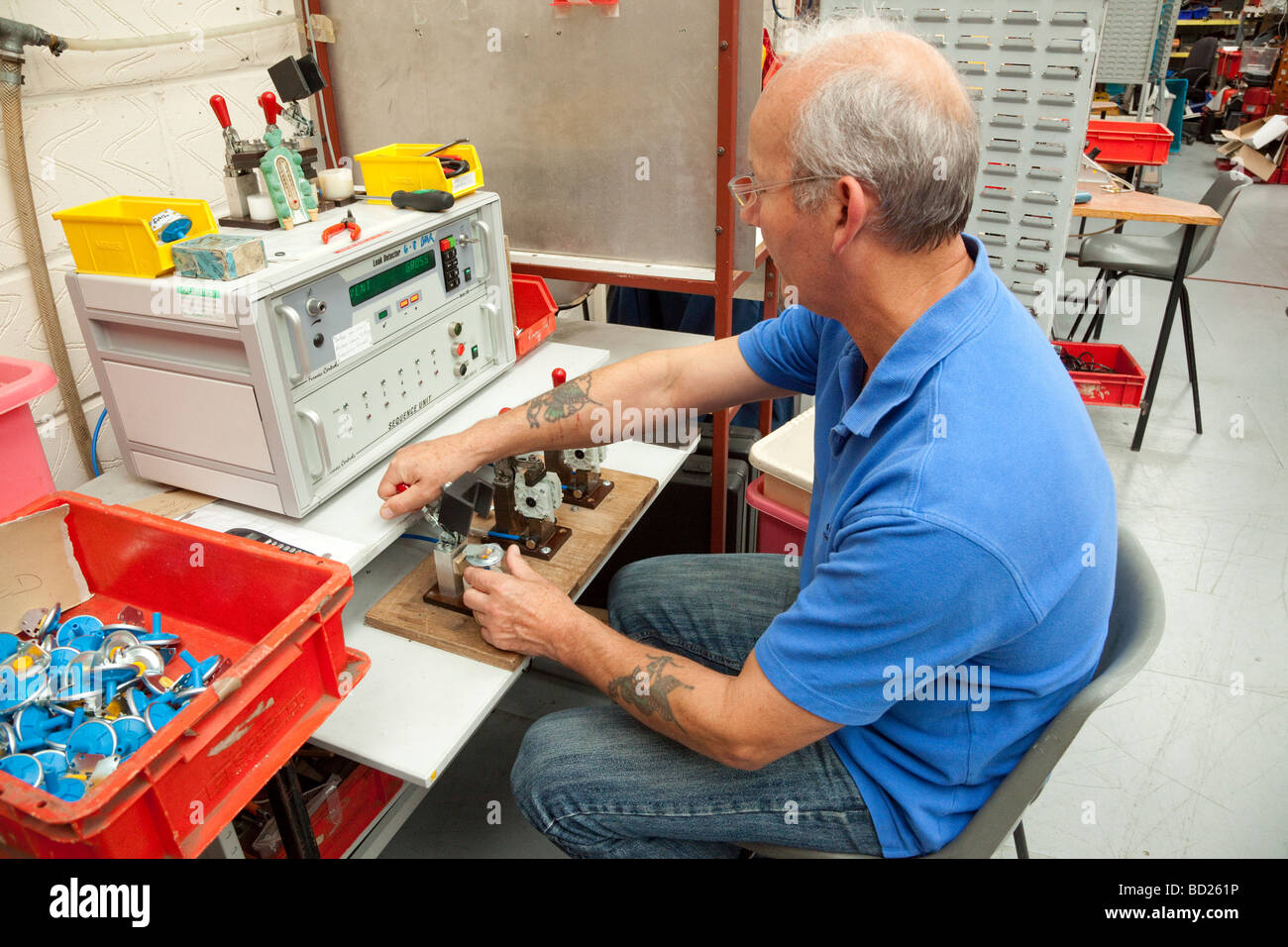 Lavoratore utilizzando apparecchiatura di prova automatizzata in una fabbrica Foto Stock