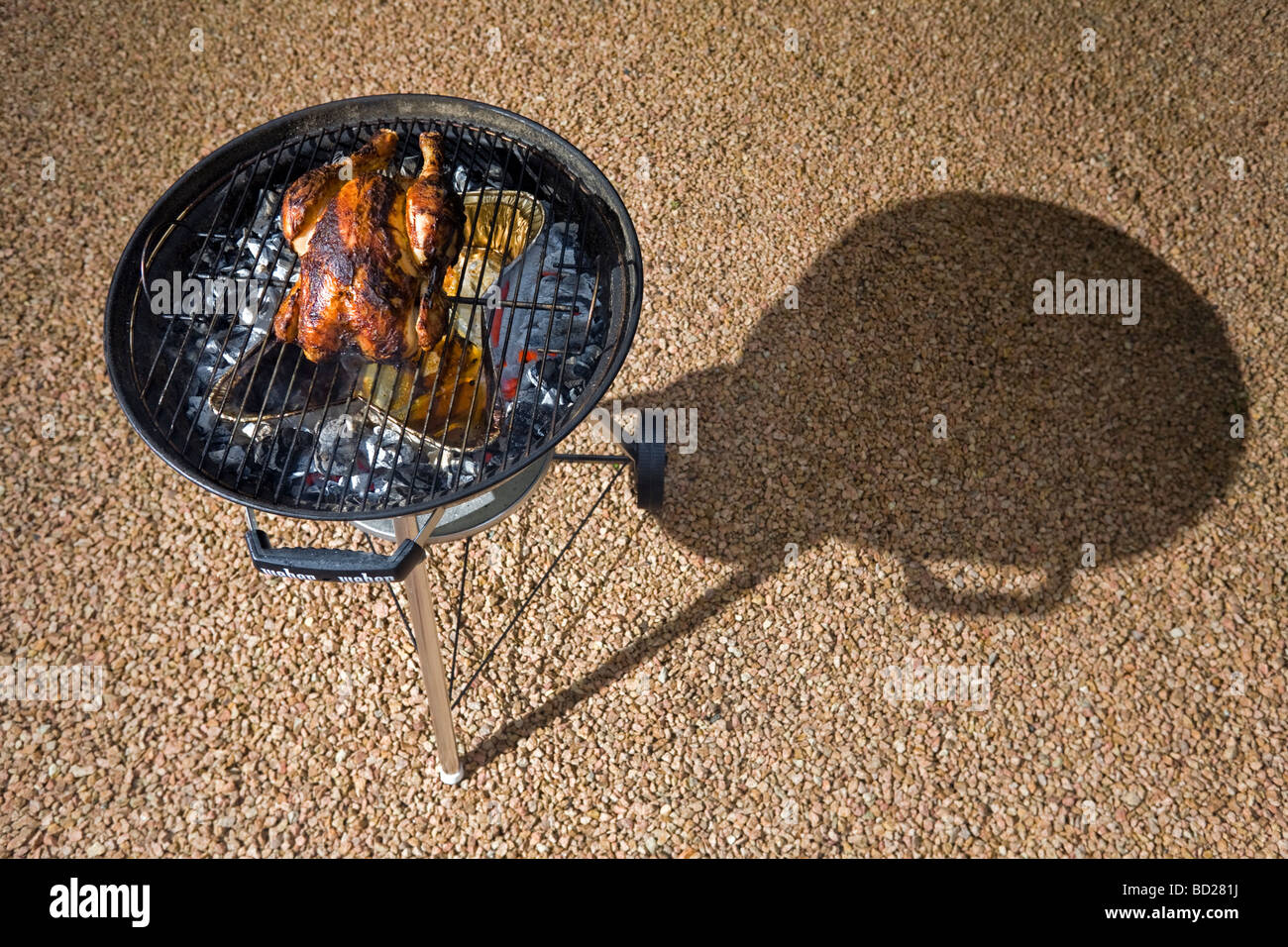 La cottura di un pollo ruspante grazie a un barbecue. Cuisson d onu poulet fermier dans un barbecue à couvercle. Foto Stock