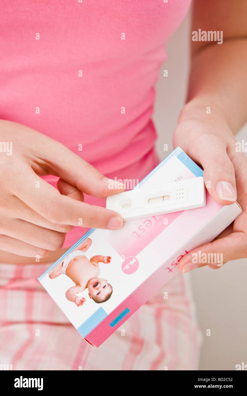 Donna che mantiene un test di gravidanza Foto Stock