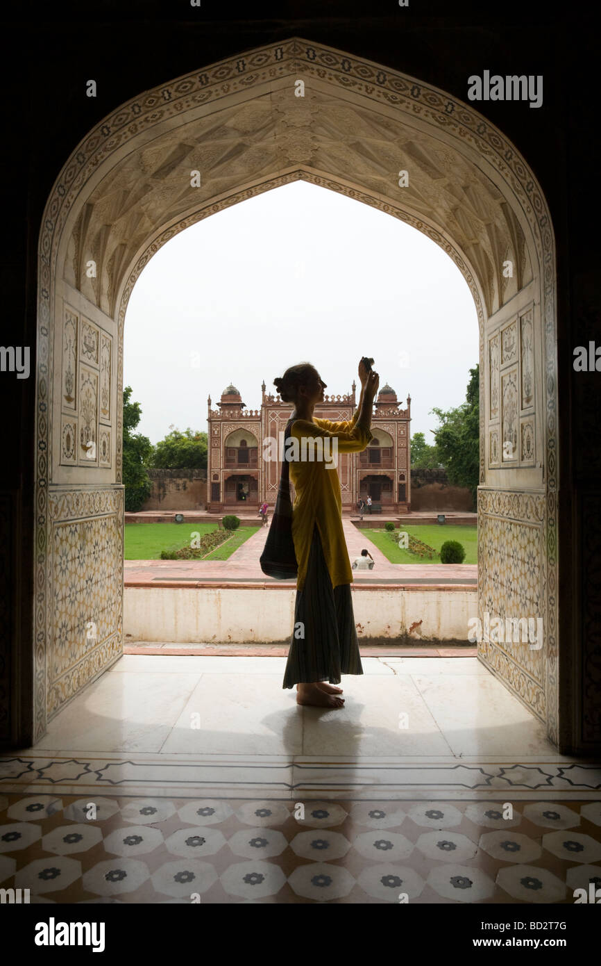 Western turista fotografare in un arco di Itmad-ud-Daulah tomba del mausoleo. Agra. India. Foto Stock