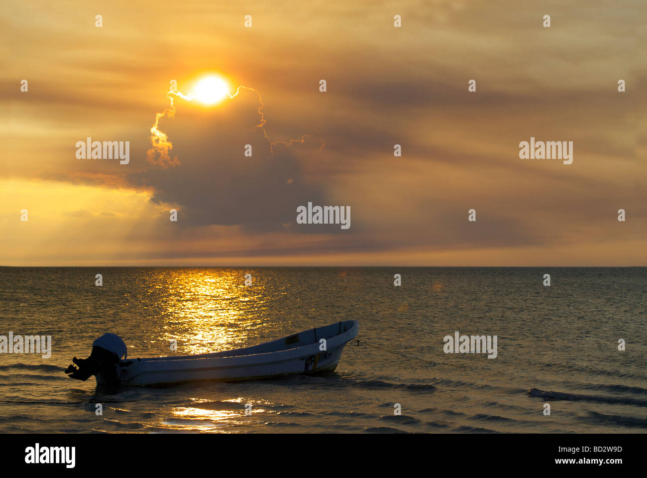 Un magnifico tramonto sull'Isola di Holbox, Quintana Roo Yucatán Penisola, Messico, barca da pesca Barche di nuvole con rivestimento in oro Foto Stock