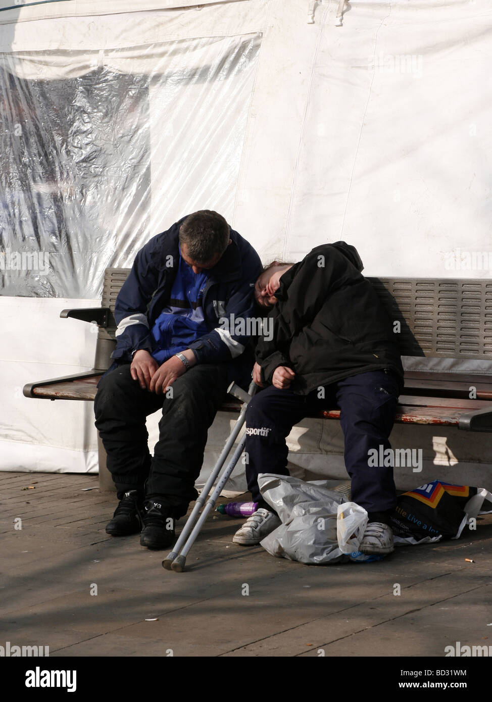 Due uomini addormentato su un centro città banco NEL REGNO UNITO Foto Stock