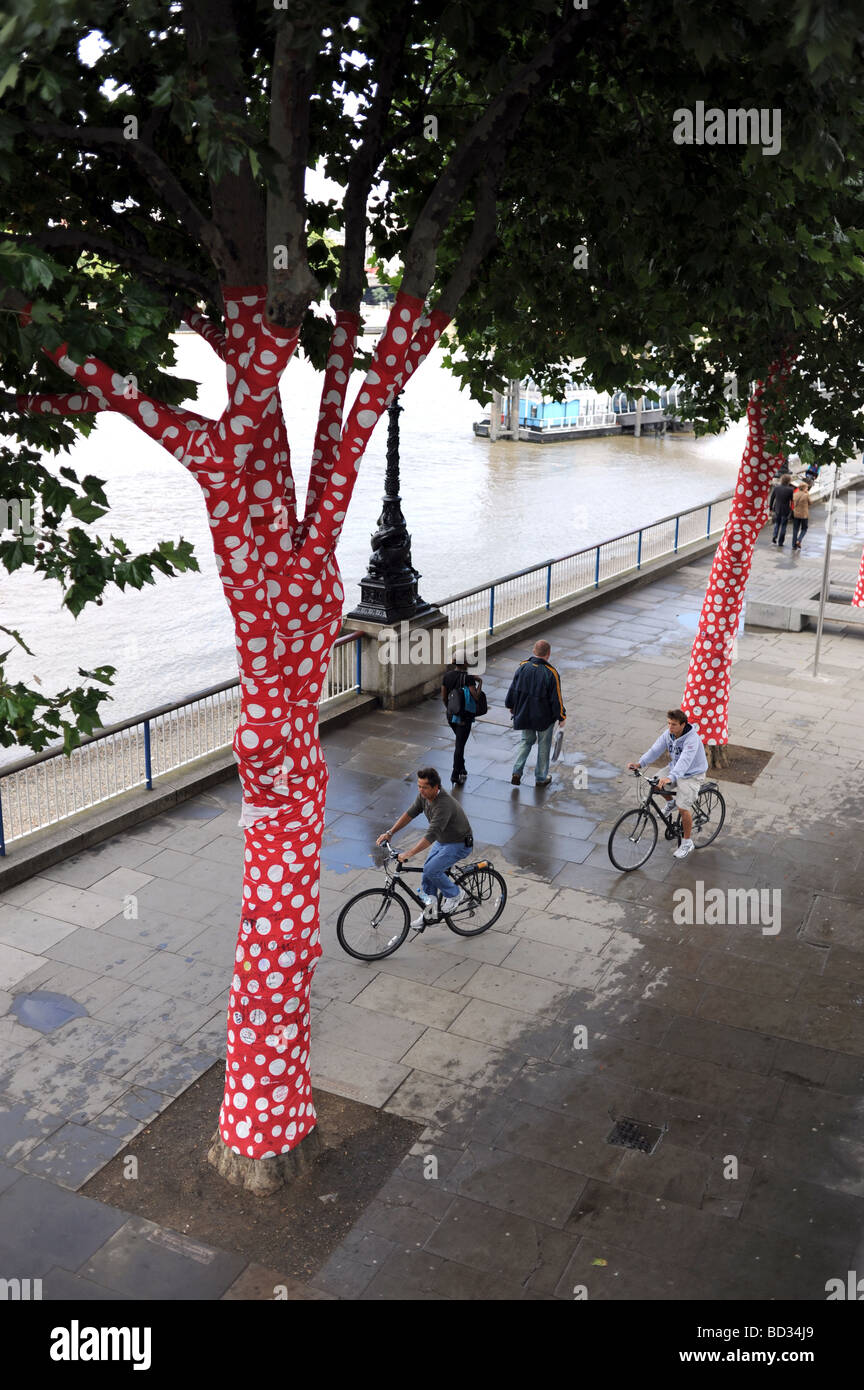Opera d'arte chiamata Ascensione dei polkadotti sugli alberi da Yayoi Kusama lungo la Southbank a Londra, Regno Unito Foto Stock