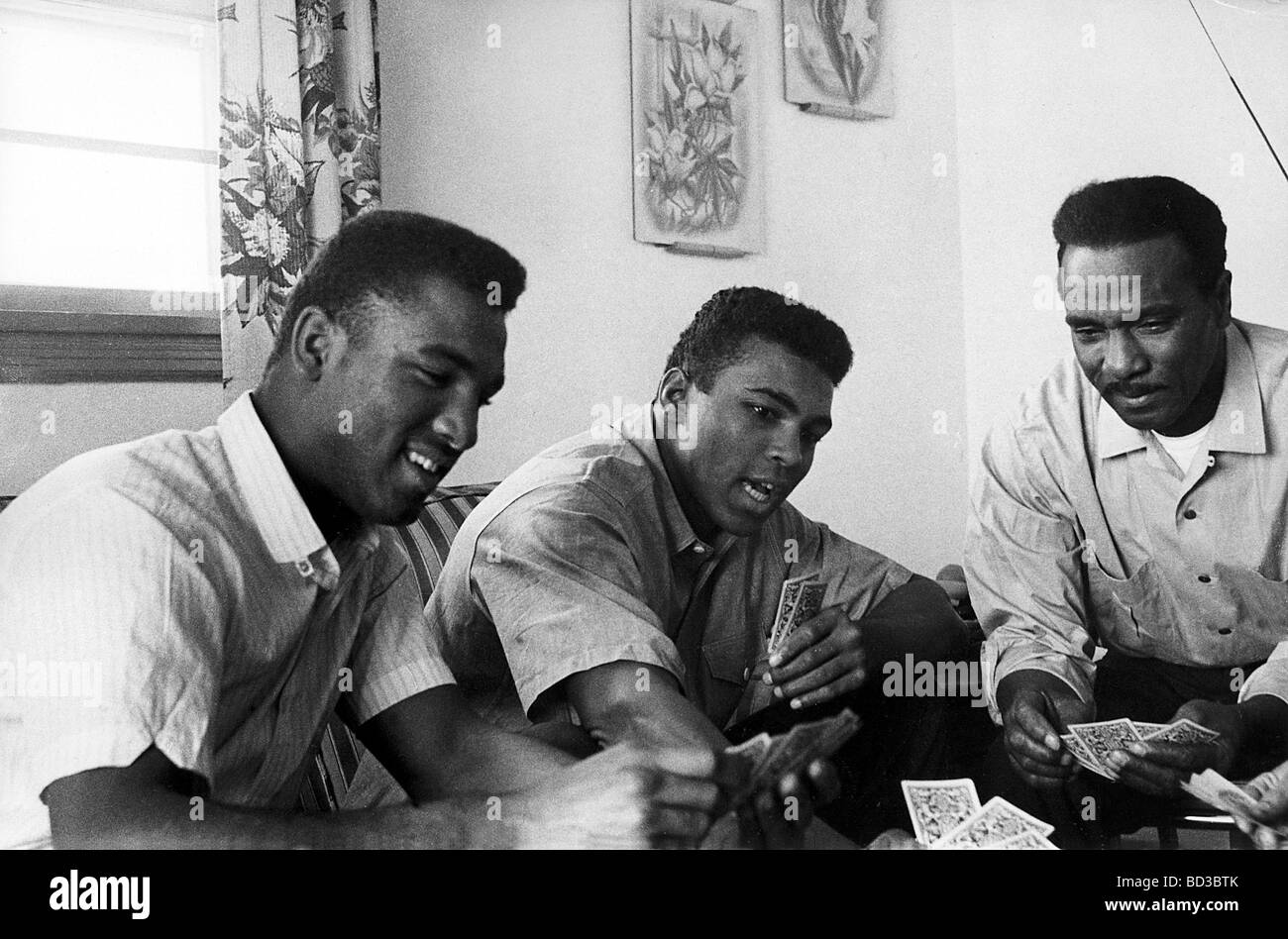 MUHAMMAD ALI center con suo fratello Rudolph a sinistra e padre Cassio giocare a carte loro Louisville, Kentucky home , circa 1 Foto Stock