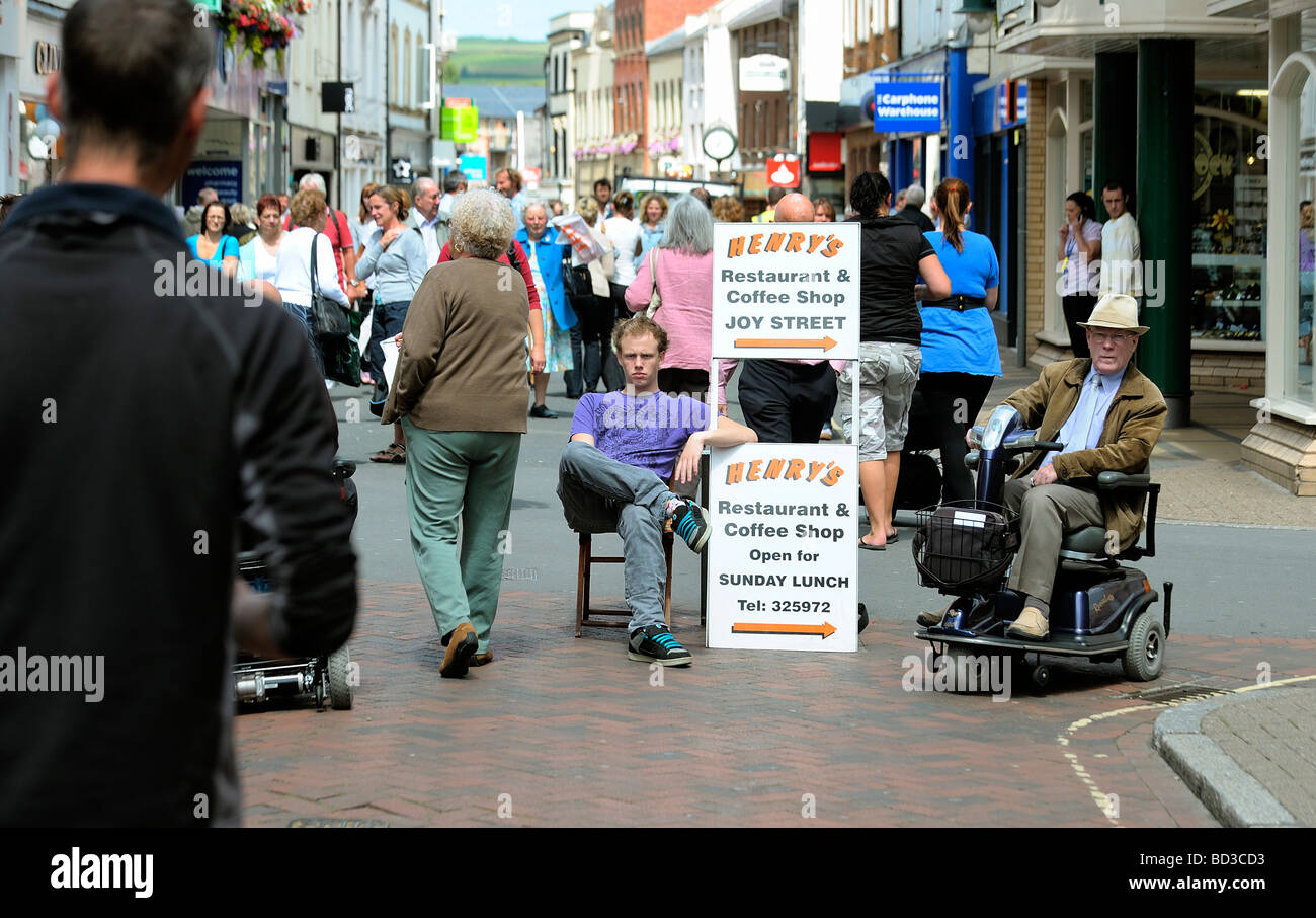 Giovane uomo seduto da scheda a sandwich pubblicità cafe ristorante Foto Stock Giovane uomo seduto da scheda a sandwich pubblicità cafe ristorante Foto Stock