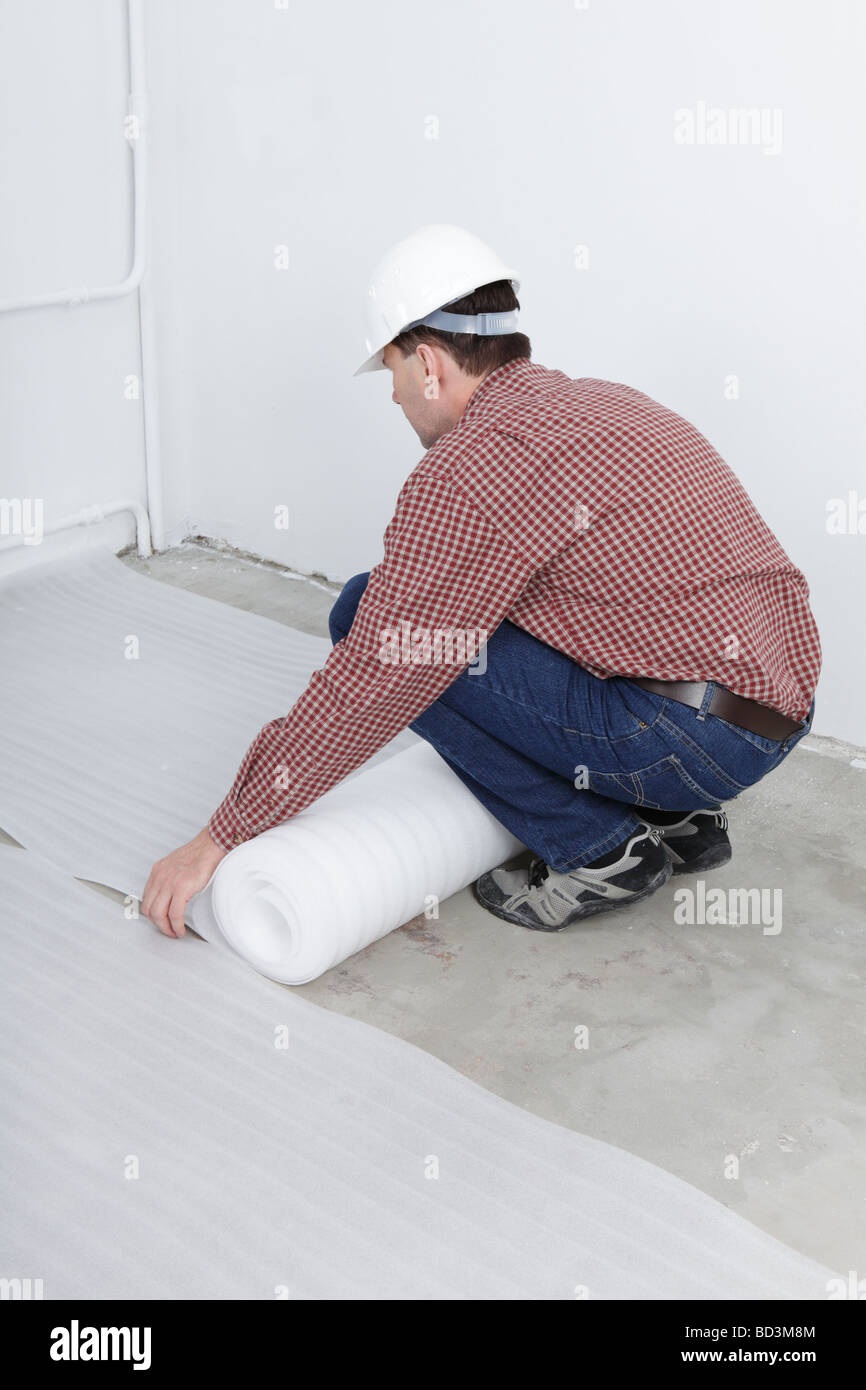 Uomo di installare il pannello per i pavimenti in laminato Foto Stock