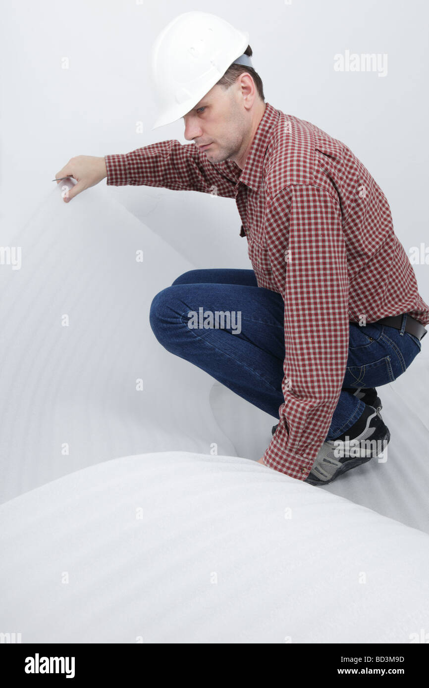 Uomo di installare il pannello per i pavimenti in laminato Foto Stock