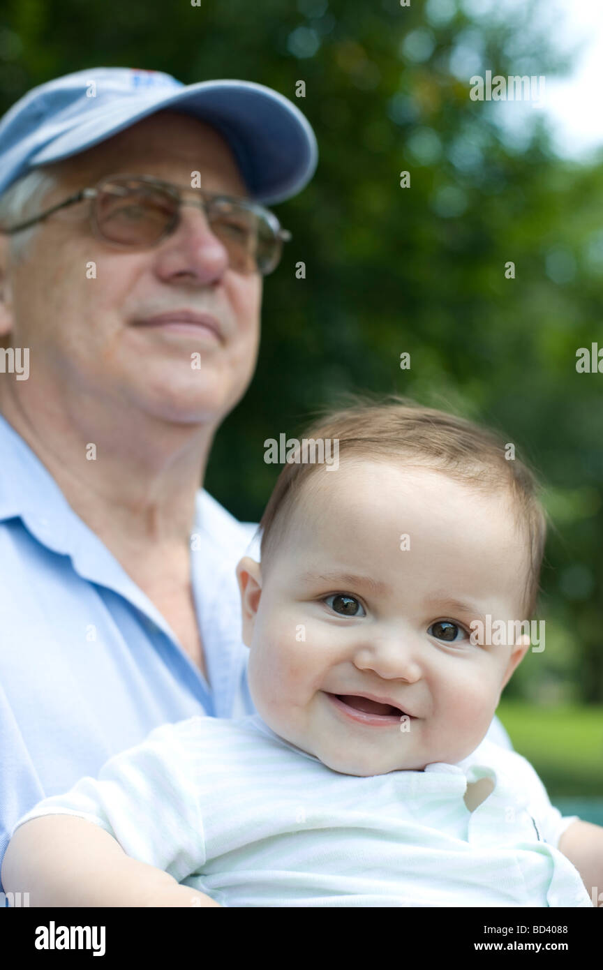 Sette mesi di età bambino guarda verso la fotocamera mentre è seduto nel parco Foto Stock