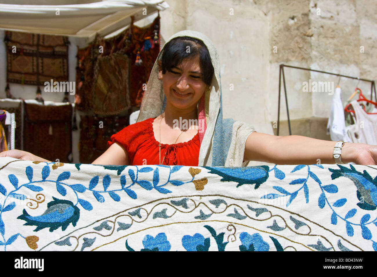 Vendita donna uzbeka tessili ricamati in Abdul Aziz Khan Madrasa a Bukhara Uzbekistan Foto Stock