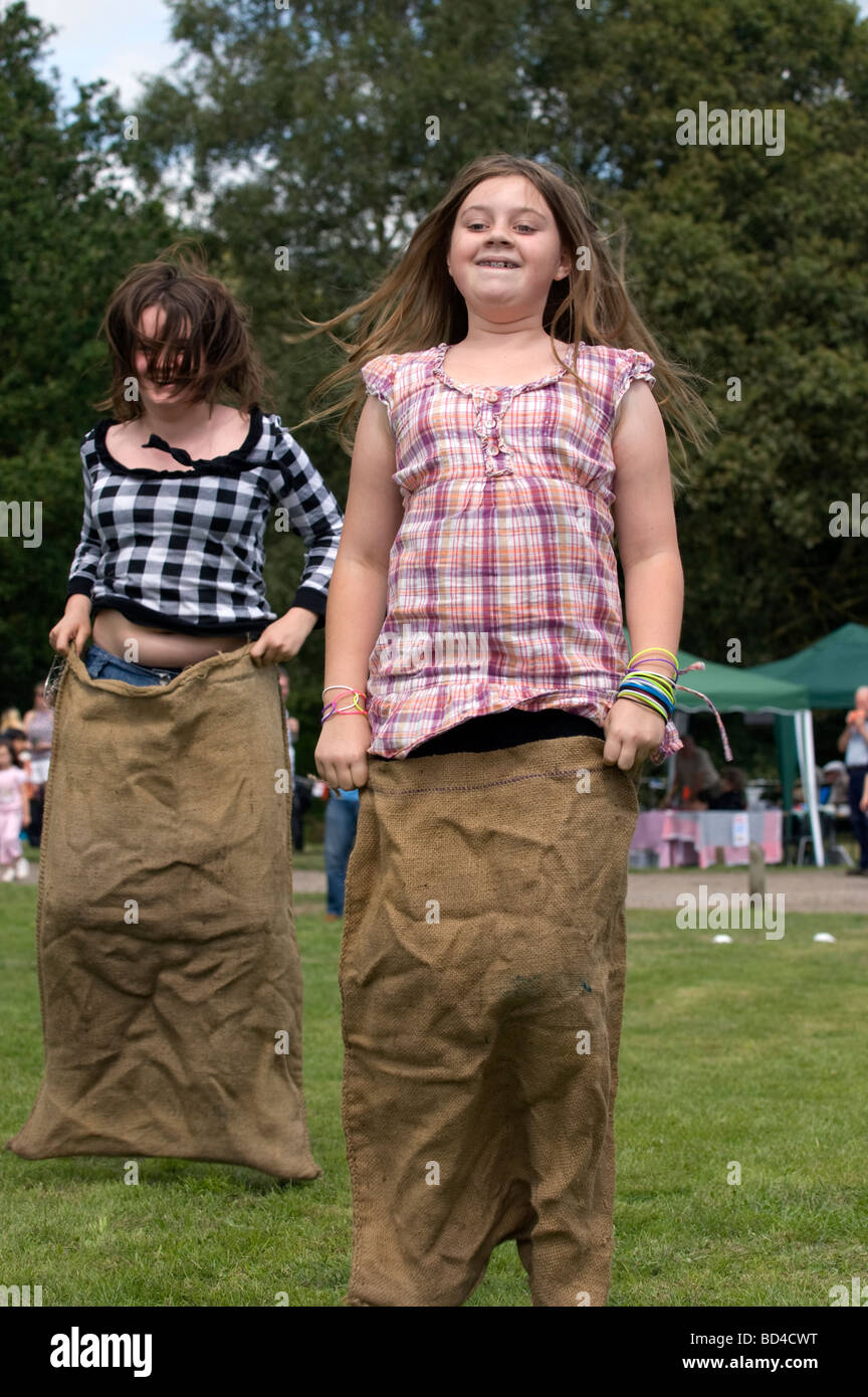 I bambini che partecipano al sacco gara a Oakhanger Village Show, Hampshire REGNO UNITO. Foto Stock