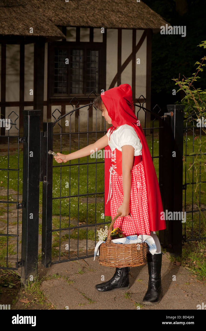 Little Red Riding Hood aprendo la porta la sua nonna's cottage Foto Stock