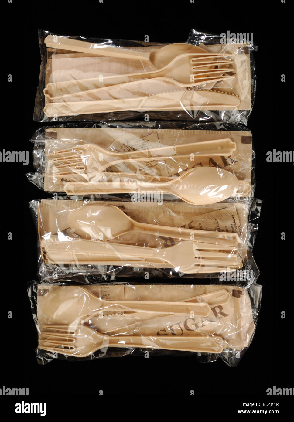 Quattro sacchetti di plastica con stoviglie su sfondo nero Foto Stock