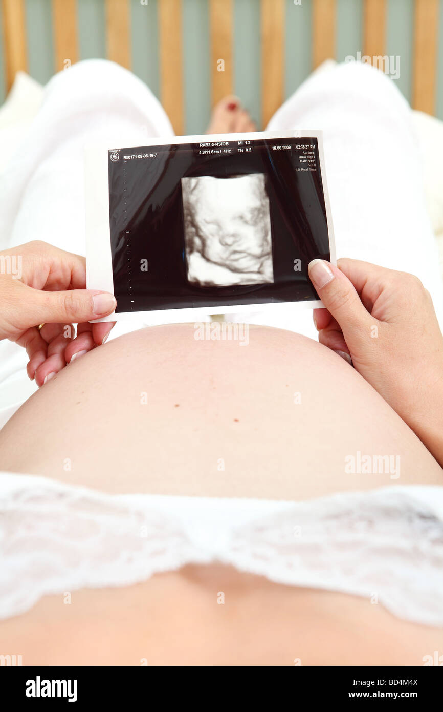 Donna incinta guardando a scansione 4d del suo bambino non nato. Foto Stock