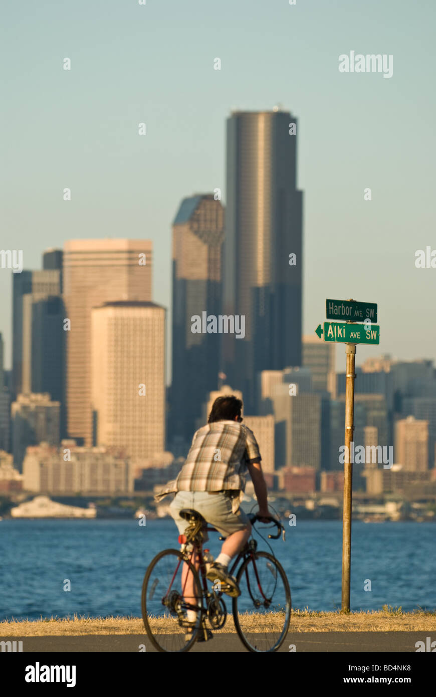 Un uomo che cavalca il suo moto lungo la spiaggia di Alki a Seattle, WA. Foto Stock