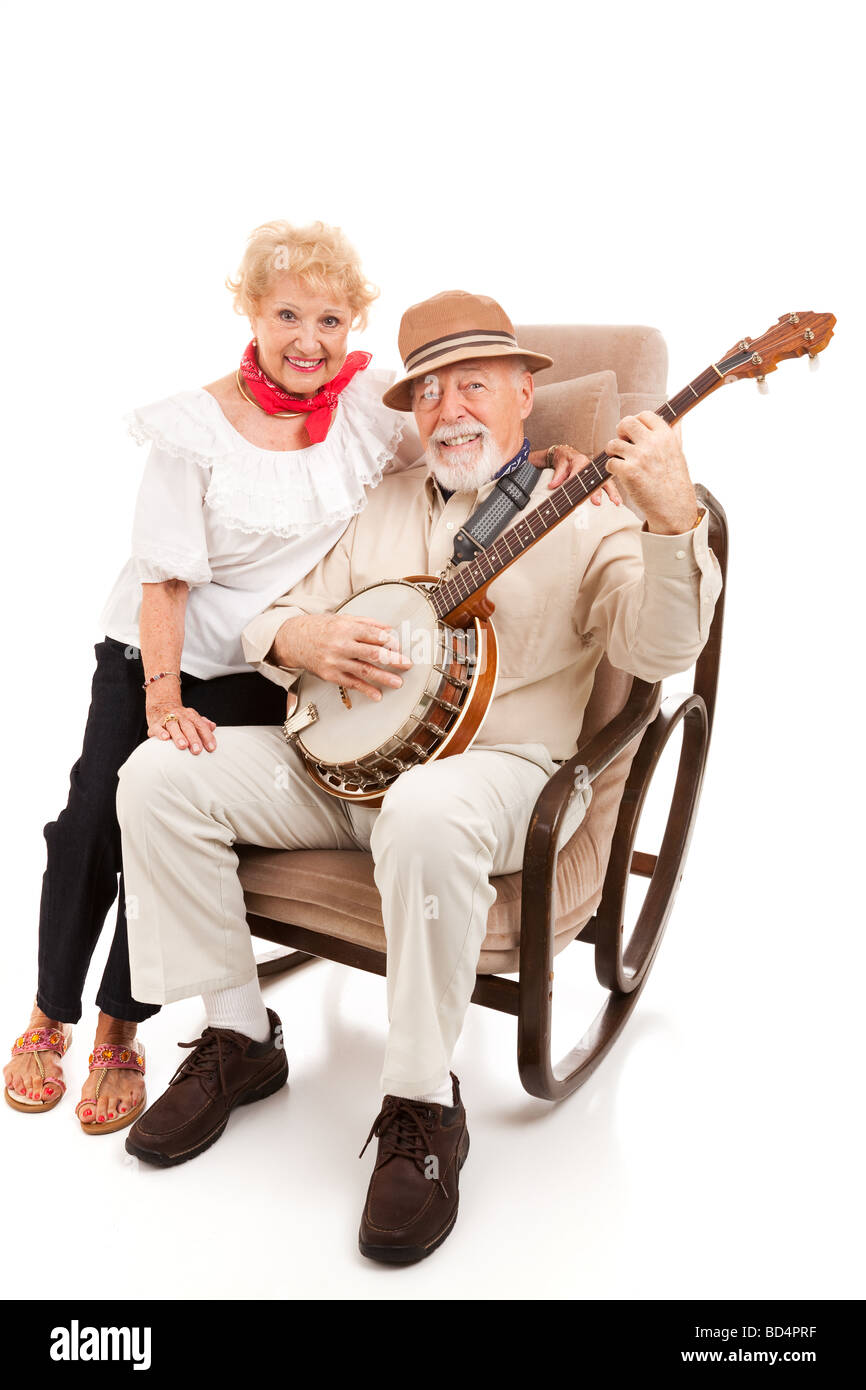 Coppia senior gode di cantare e suonare musica paese isolato su bianco Foto Stock