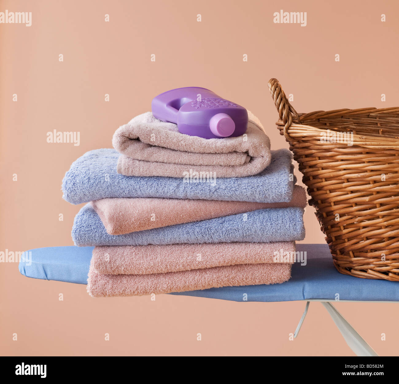 Un asse da stiro con asciugamani e detergente Foto Stock