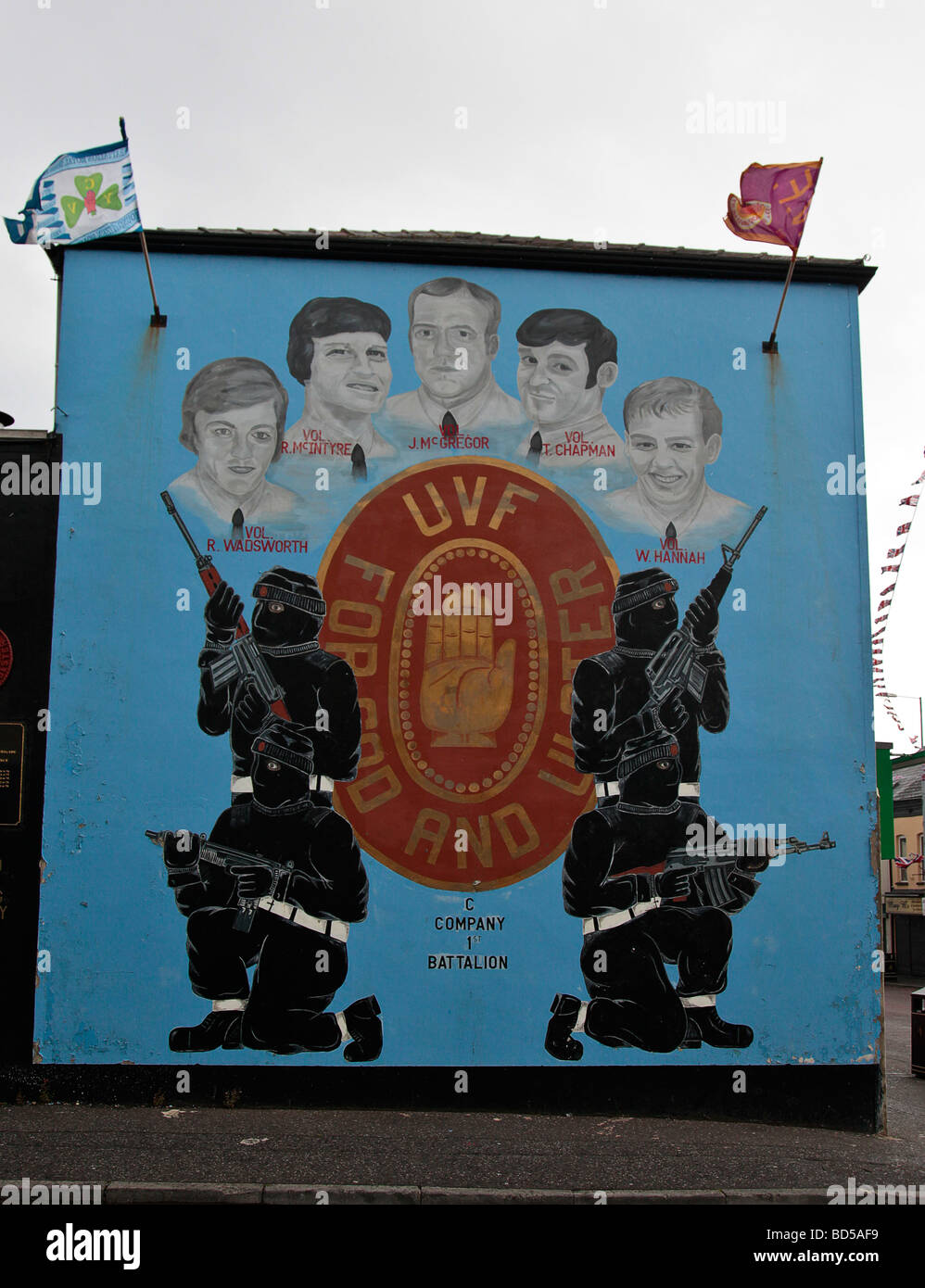 Il Murale in lealisti area della parte occidentale di Belfast che mostra l'UVF, con incappucciati paramilitari e ritratti di cinque membri UVF Foto Stock