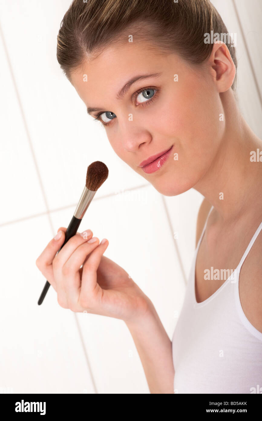 Cura del corpo - donna bionda l'applicazione di polvere nella stanza da bagno Foto Stock
