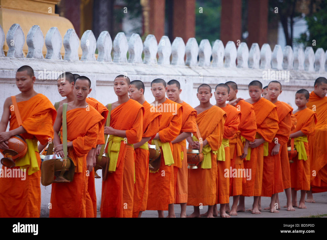 I monaci a piedi attraverso le strade all'alba per raccogliere doni alimentari, Luang Prabang, Laos Foto Stock