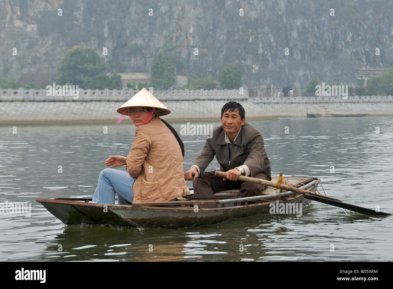 Coppia vietnamita in barca a remi Tam Coc Lago di Ninh Binh Provincia Nord Vietnam Foto Stock