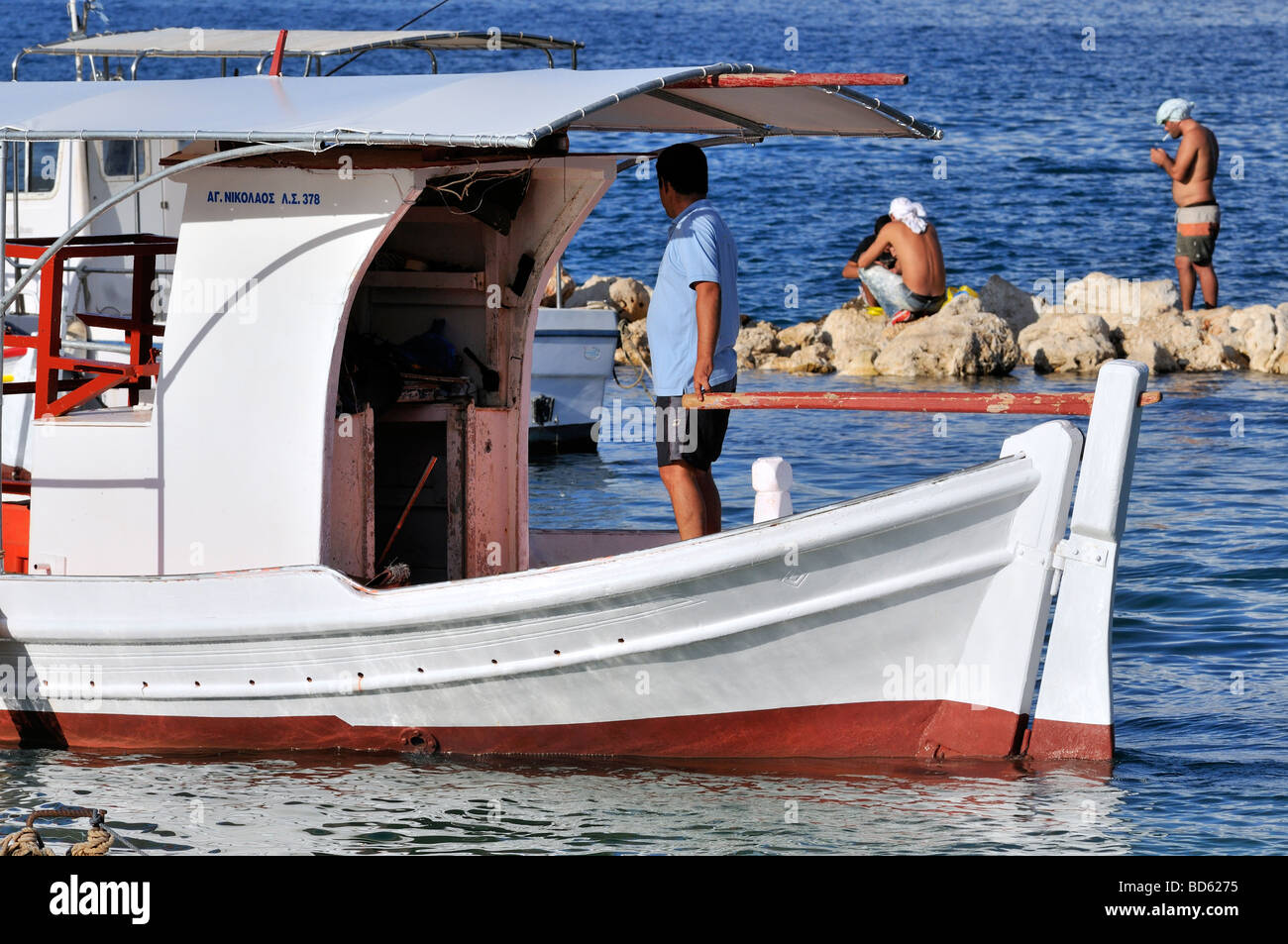 Pescatore greco con la barca da pesca nel mare greco Foto Stock