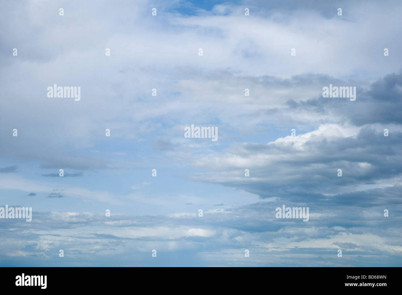Soft misty cumulus e grigio stratus nuvole, con un cielo blu al di là. Foto Stock