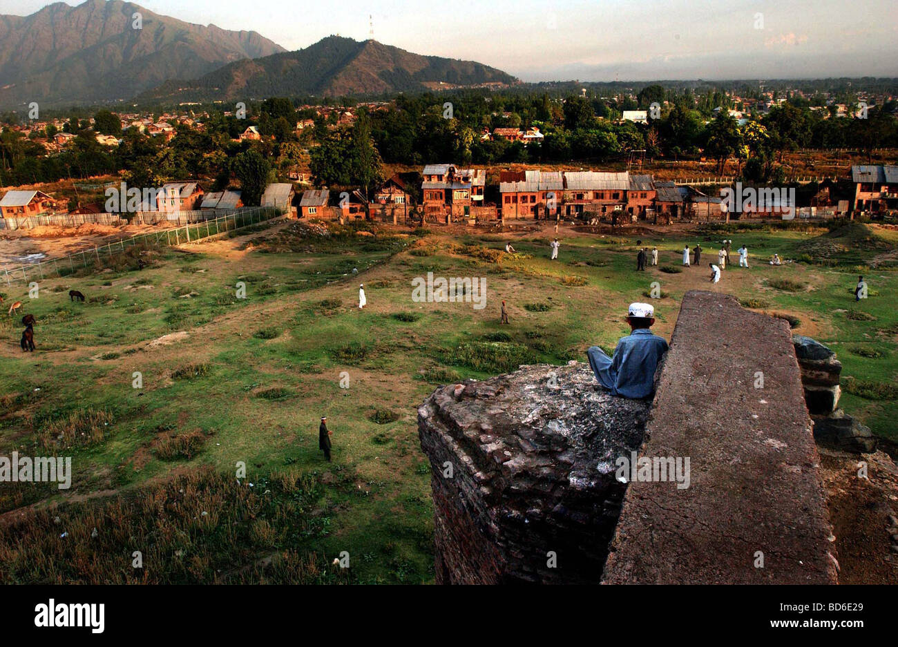 Il Kashmir India 29 luglio un ragazzo del Kashmir che studiano in una madrassa si trova sulla cima di uno sbriciolamento moschea con dossi e guarda i suoi compagni di classe Foto Stock