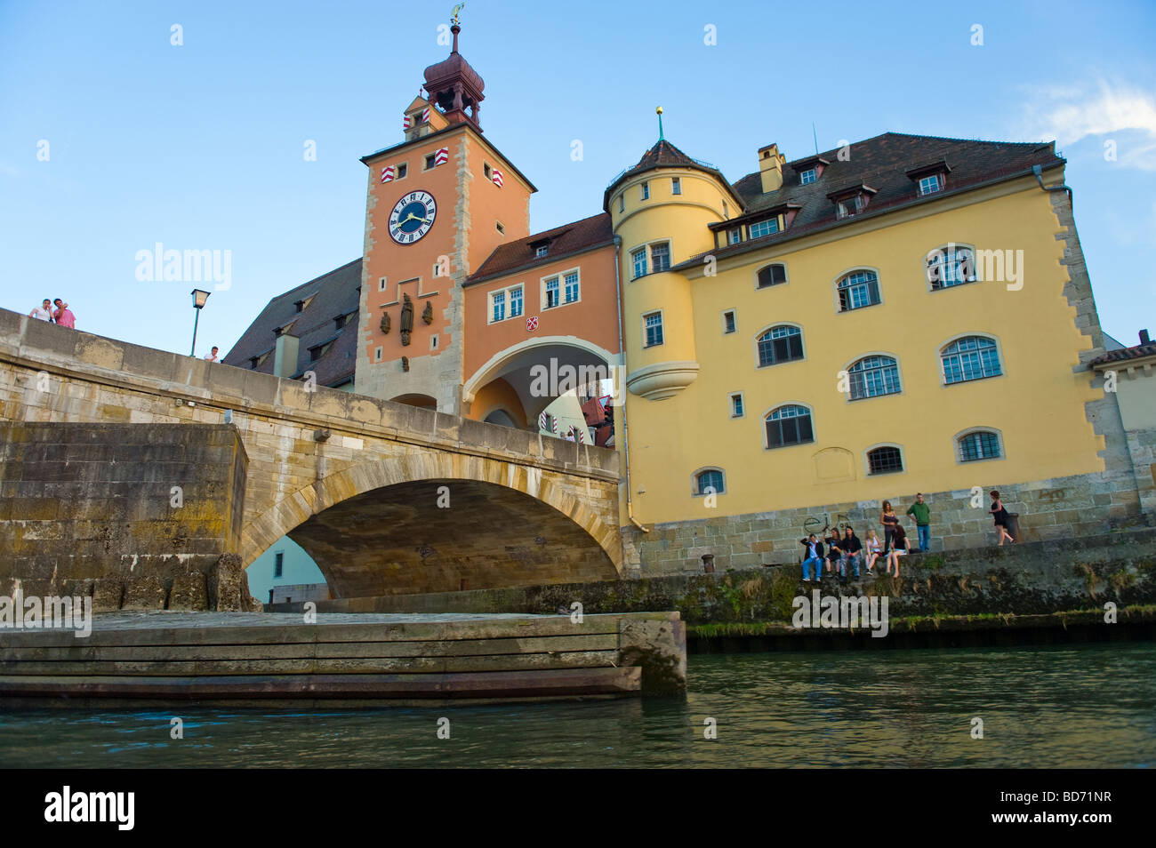REGENSBURG waterview giovani sit seduta riverside a lato del fiume Danubio Salzstadel Brückturm al fiume Danubio vecchio Stonebridge Foto Stock