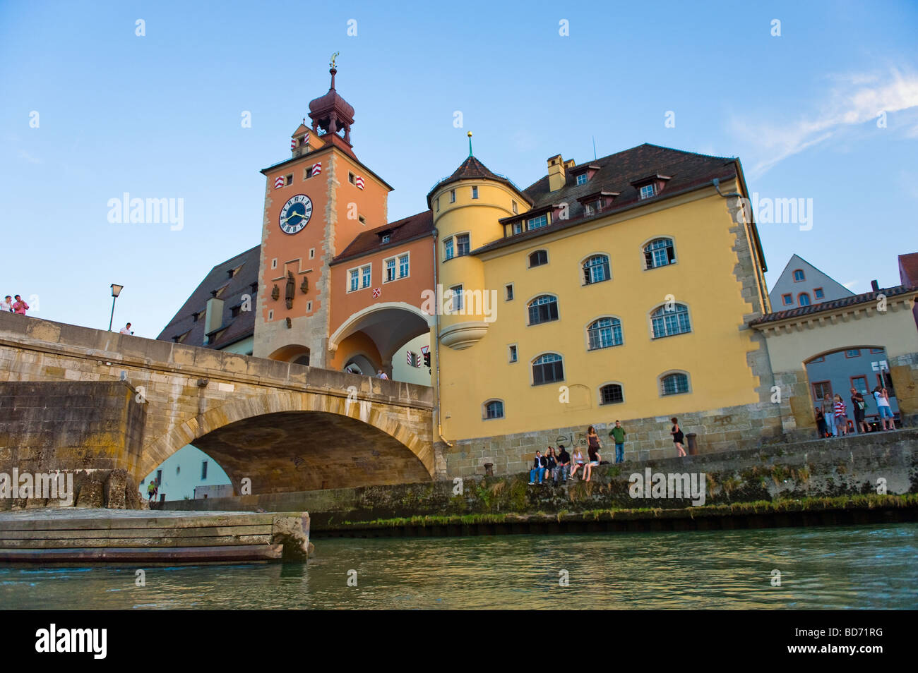 REGENSBURG waterview giovani sit seduta riverside a lato del fiume Danubio Salzstadel Brückturm al fiume Danubio vecchio Stonebridge Foto Stock