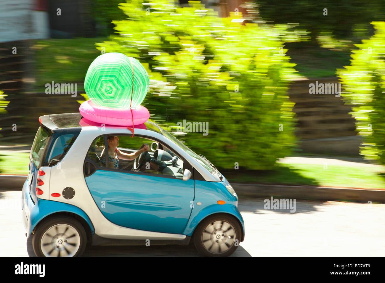 Donna con palla spiaggia su smart auto Foto Stock