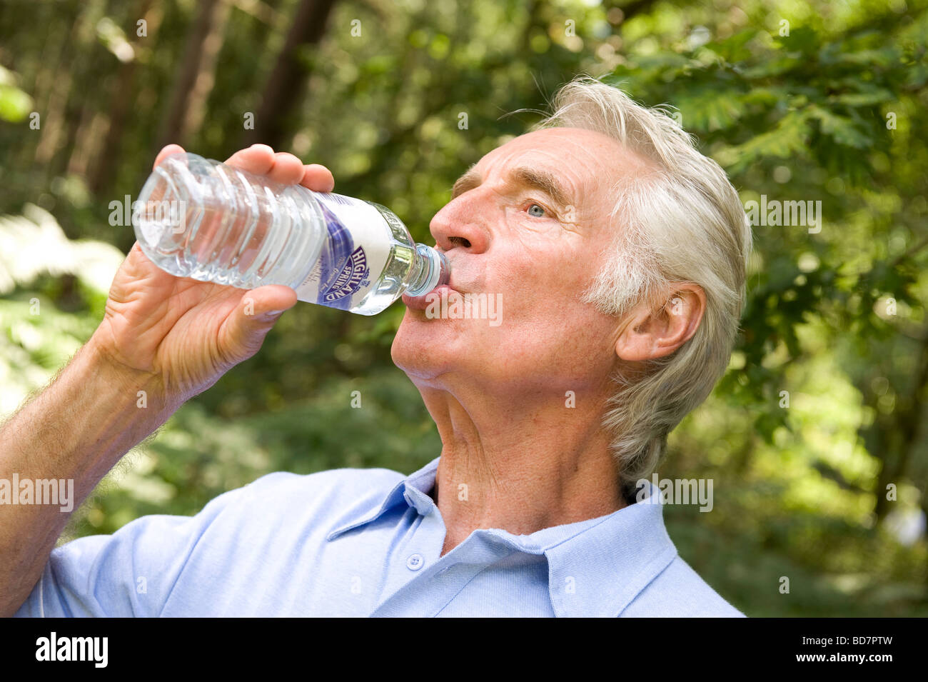 Uomo maturo di bere acqua minerale in bottiglia Foto Stock