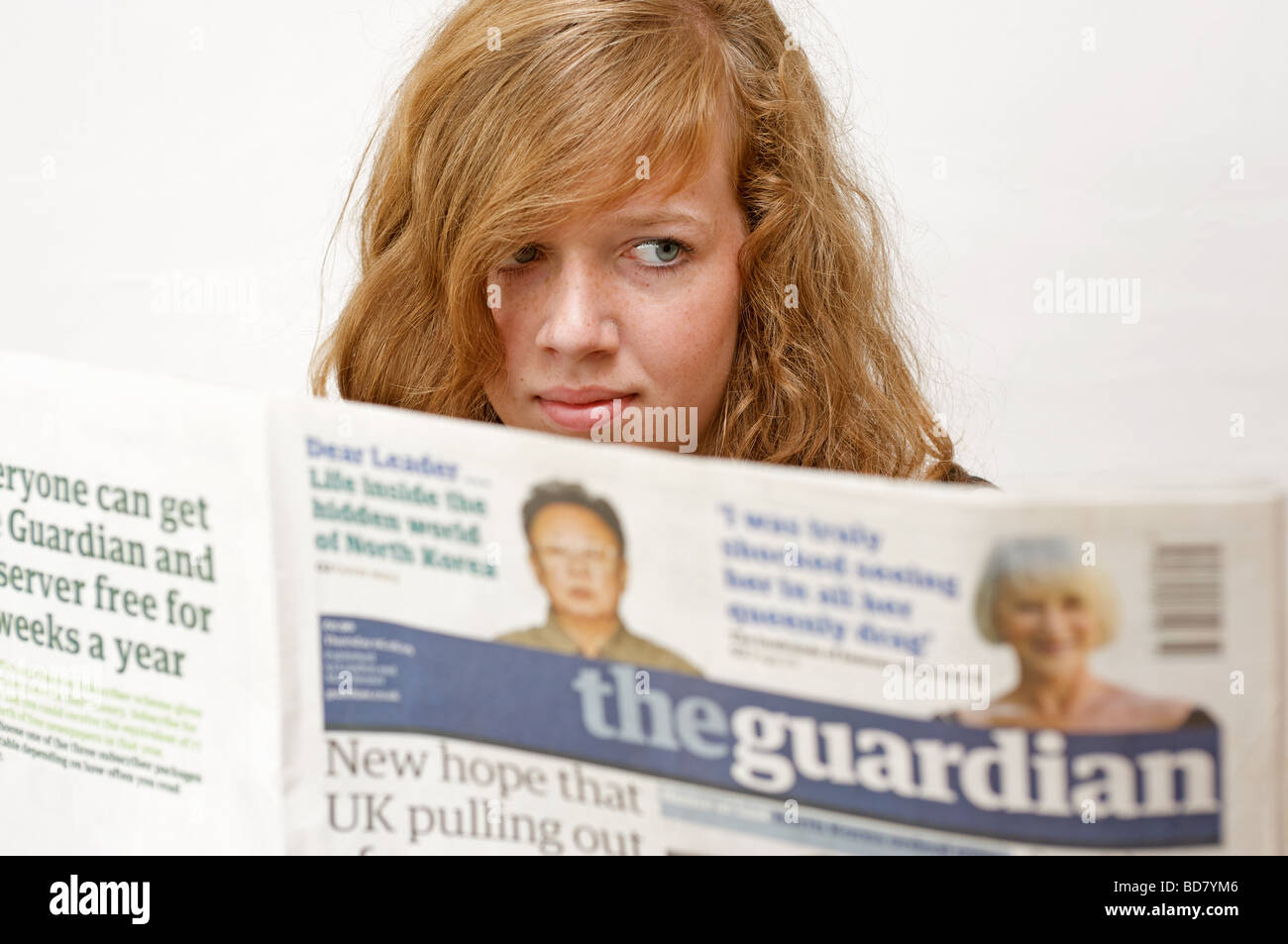 Ragazza adolescente leggendo il quotidiano The Guardian Foto Stock