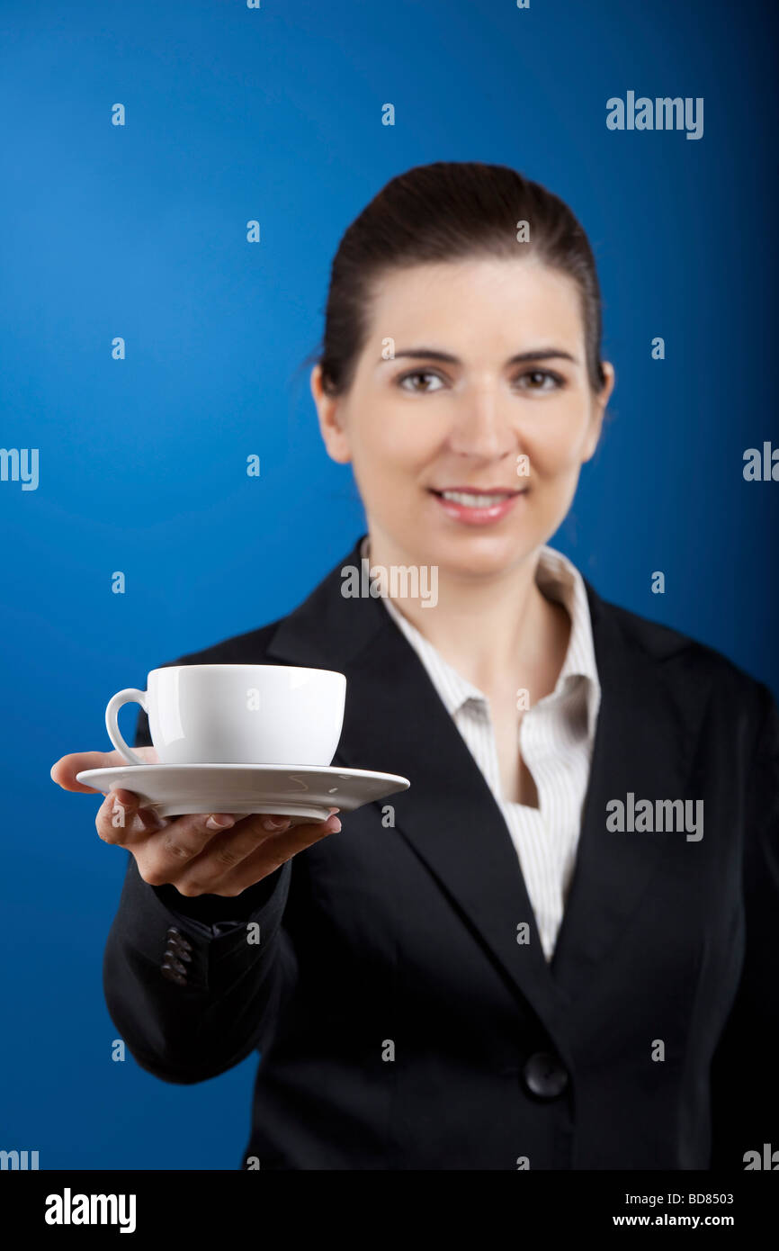 Giovane e bella donna d'affari offrendo una tazza di tè Foto Stock