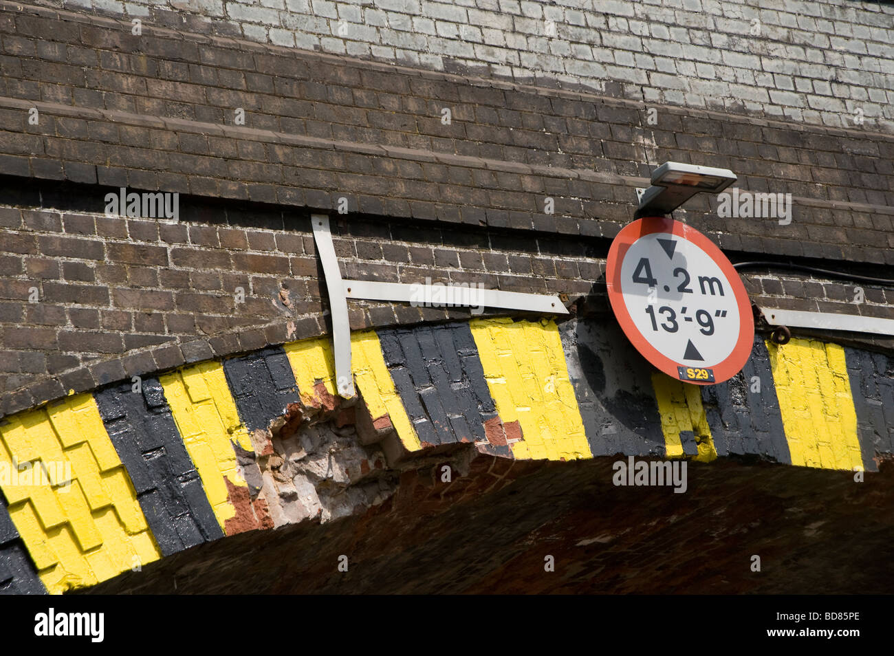 Ponte Basso segnale di avvertimento su un mattone ponte ferroviario Foto Stock