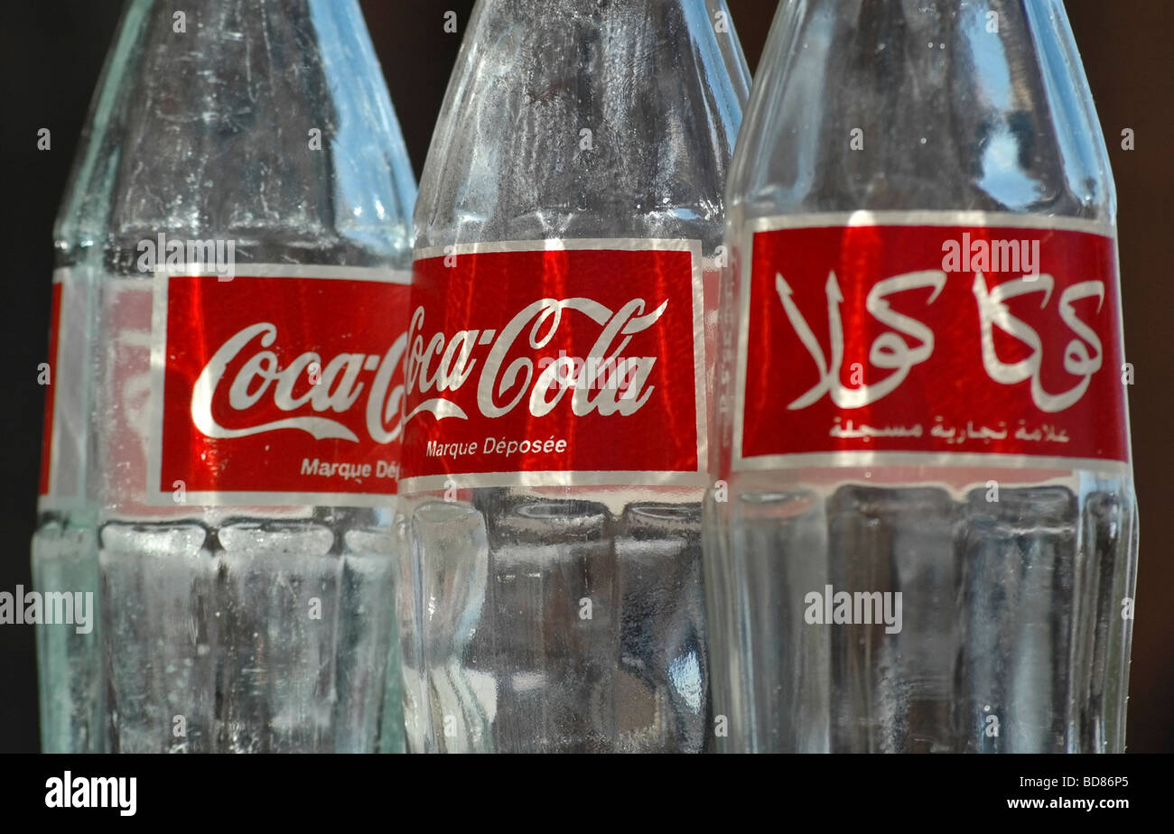 Tre coca cola bottiglie che mostra sia la lingua inglese e la lingua araba di ortografia e loghi. Preso in Marocco Foto Stock