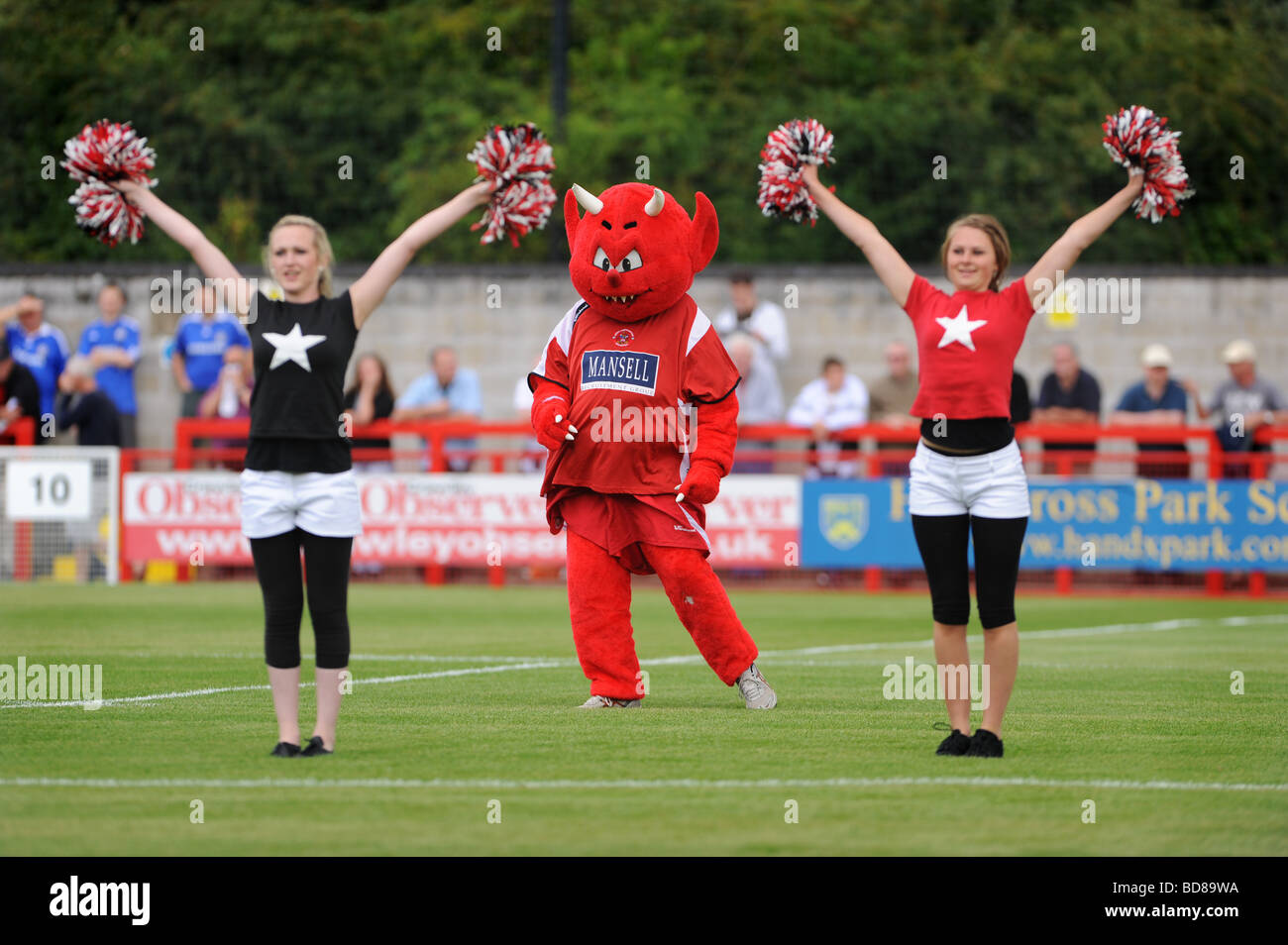 Il Crawley town football club mascotte un diavolo rosso intrattiene la folla prima di kick off Foto Stock