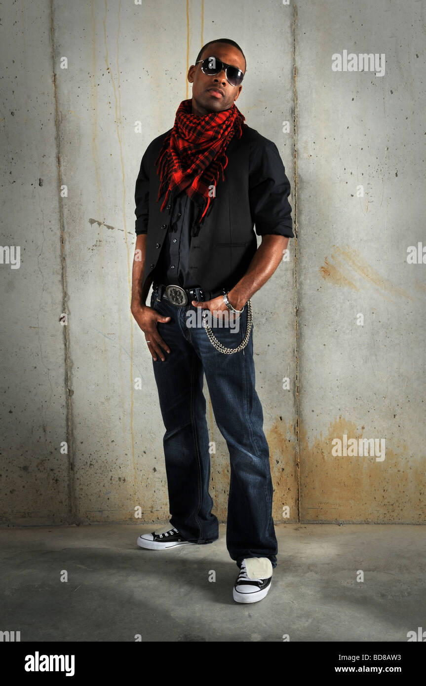 African American uomo in piedi contro la parete di grunge Foto Stock
