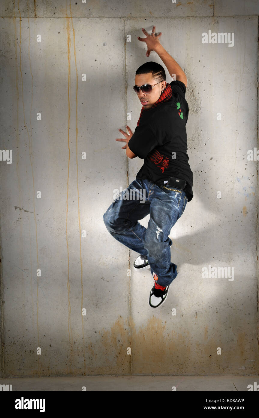African American hip hop uomo jumping contro il muro Foto Stock
