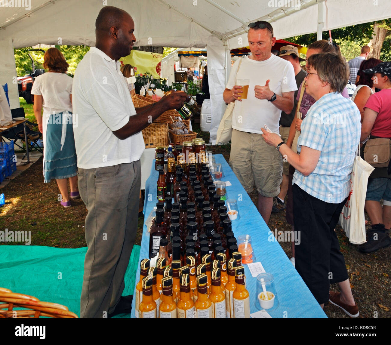 Persone che cercano varie salse. West Dean Chili Fiesta, West Sussex, in Inghilterra, Regno Unito. Foto Stock