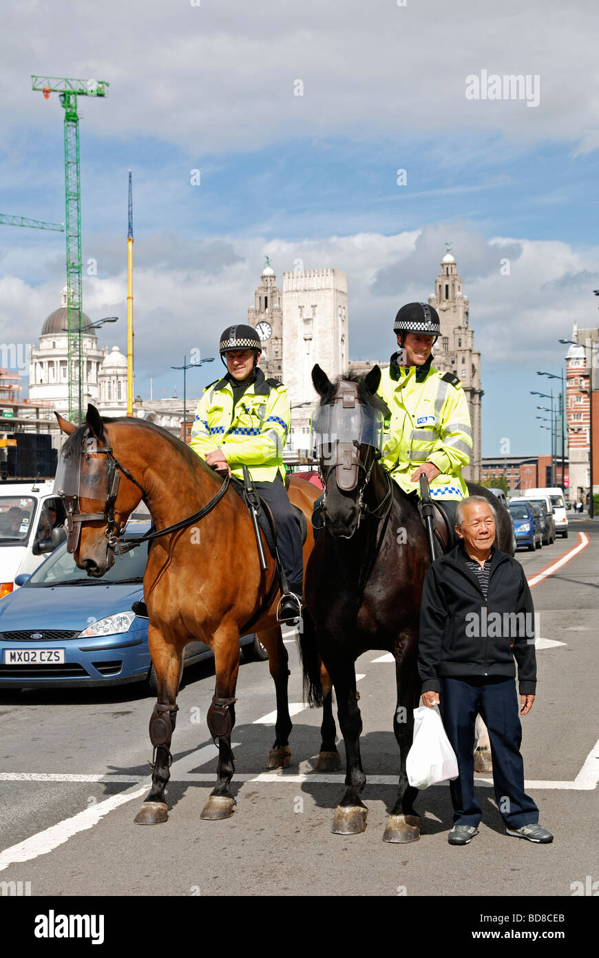 Un turista orientale avente la sua fotografia scattata con la polizia horseriders in liverpool,l'Inghilterra,uk Foto Stock