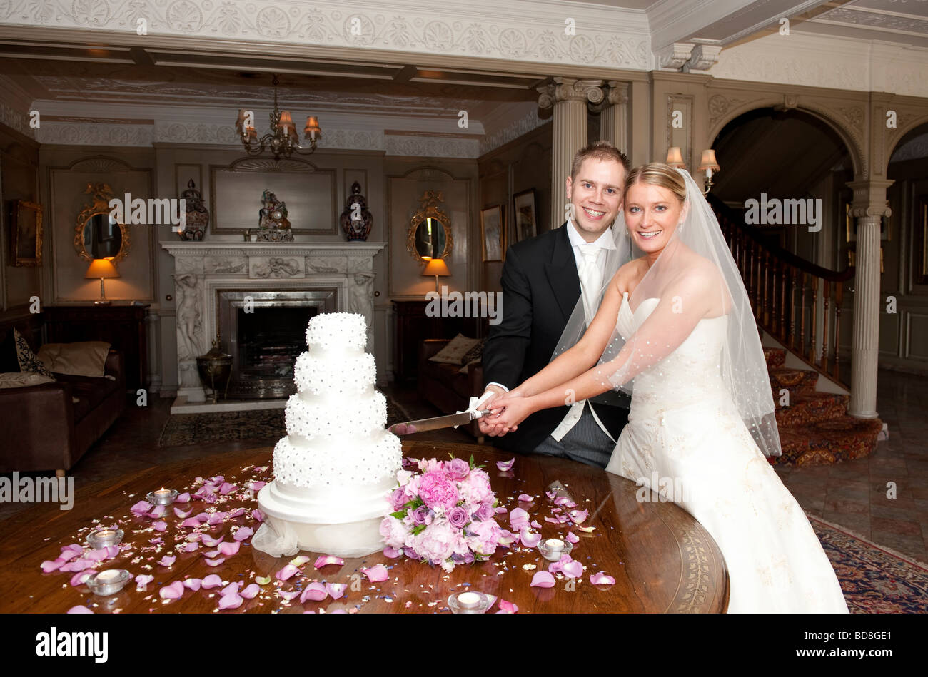 Sposa e lo sposo il taglio della torta di nozze Foto Stock