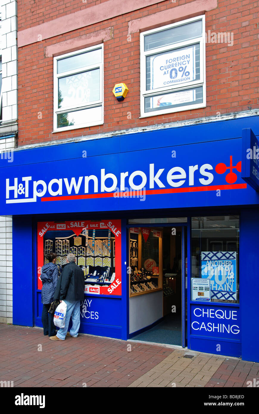 Una coppia in cerca di una finestra pawnbrokers in st.helens,lancashire, Regno Unito Foto Stock