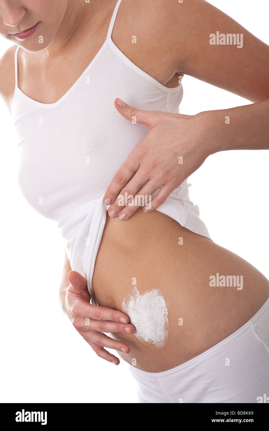 Cura del corpo - Donna di applicare la crema sul suo ventre Foto Stock