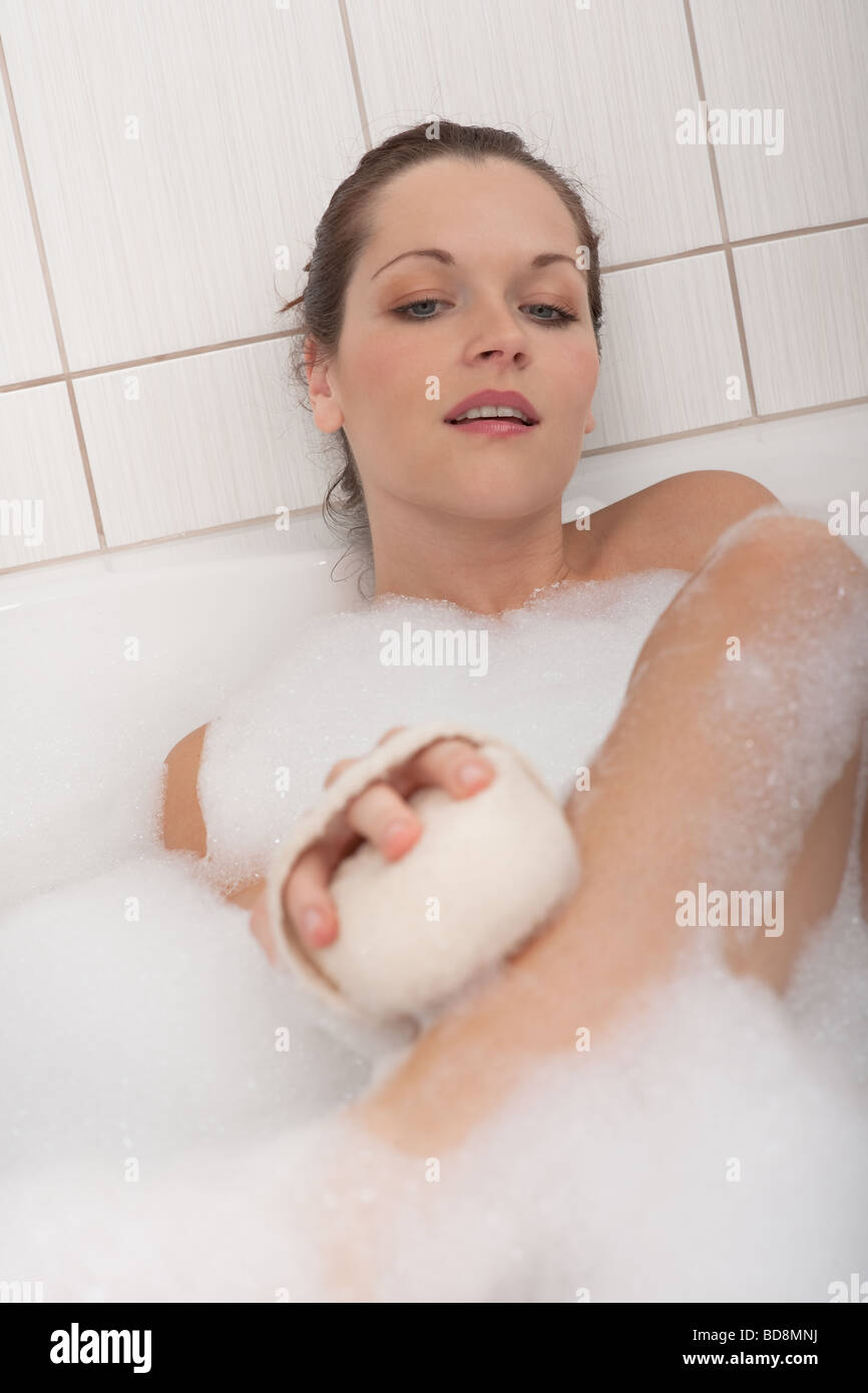 Cura del corpo - bella giovane donna avente vasca da bagno con schiuma Foto Stock