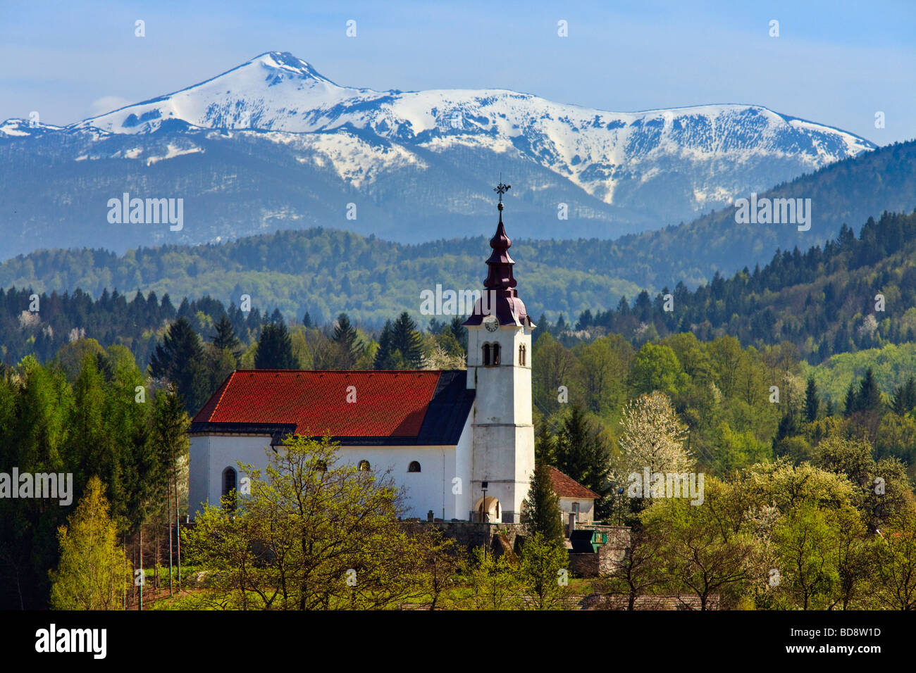 Chiesa slovena con sfondo di montagne Foto Stock