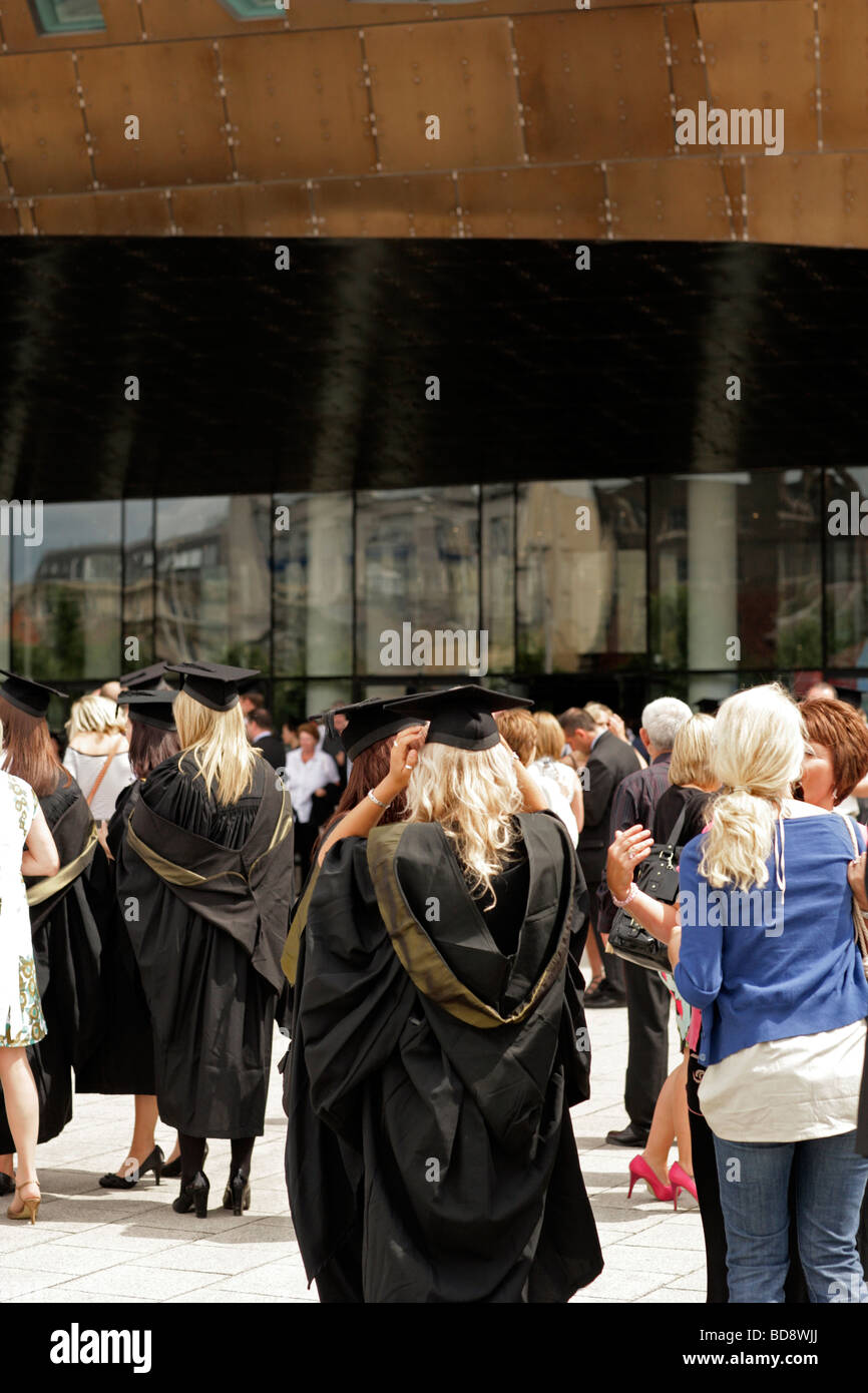 Giovani laureati sul giorno di graduazione con mortaio board cappelli e abiti Foto Stock